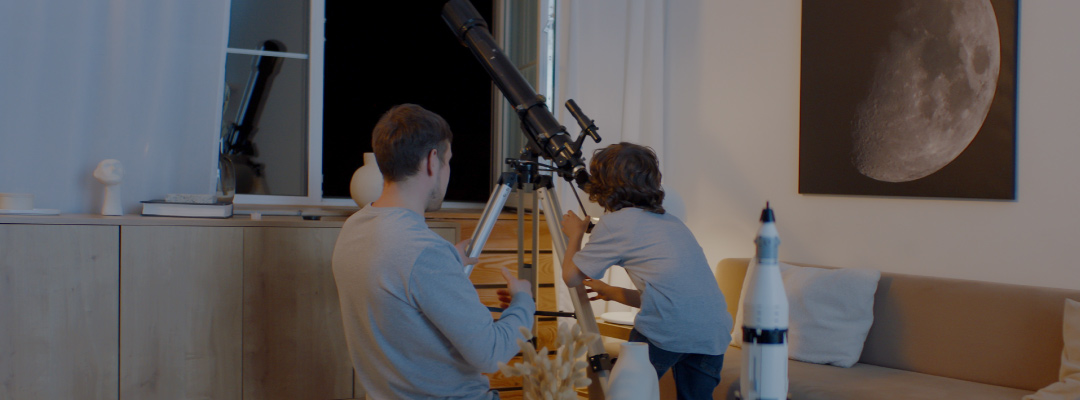 Father and son looking into a telescope. 